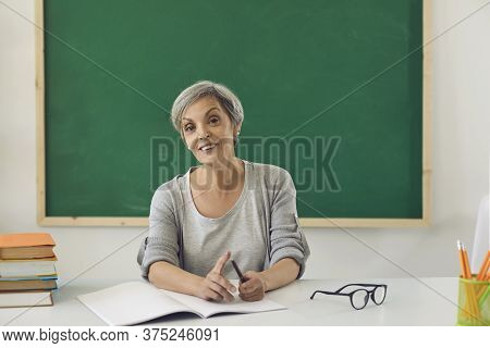 The Teacher Is Looking At The Camera Online. Female Senior Teacher Teaches Students Remotely Using C