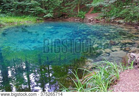 Clear Blue Mountain Lake In Summer Forest, Romanian Carpathians Landmark, Ochiul Beiului Lake