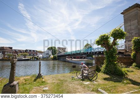 A Cyclist Rest By The River Thames In Marlow, Buckinghamshire At Marlow Bridge In The Uk Taken 20th 
