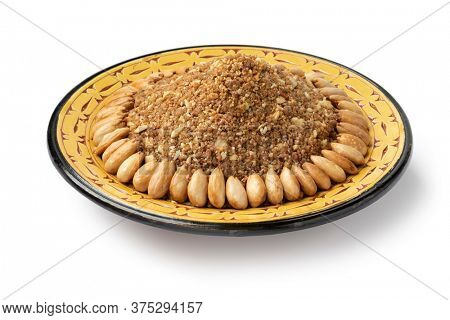 Dish with traditional Moroccan homemade sellou decorated with roasted almonds isolated on white background