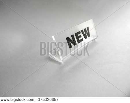 The Inscription New Of A Shop Price List. Plastic Price Tag On A Light Background For Goods Or Trade