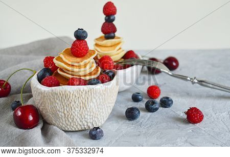 Pancake Cereal, Mini Pancakes In A Bowl With Blueberries, Raspberries, Cherries. Healthy Nutrition. 