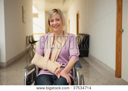 病院の廊下にスリングで腕に患者の車椅子