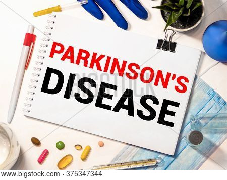 Parkinson's Disease Text On Paper With Heart Beat Diagram, Stethoscope, Delicious Green Apple, Measu