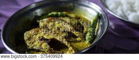 Hilsa Fish Curry With Mustard Paste And Green Chilli Served On Plate Along Side Rice With Selective 