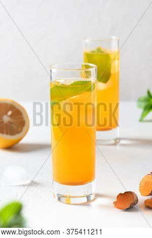 Jamu Indonesian Herbal Beverage With Turmeric, Ginger, Lemon On White Background. Close Up. Vertical