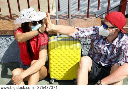 Man And Woman In Medical Masks With Suitcase Go On Trip. Covid 19 Travel 2020 Concept
