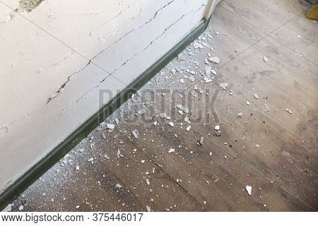 Apartment Interior Renovation. Old Wallpaper Partially Scraped Off. Dirty Torn Wallpaper On The Floo