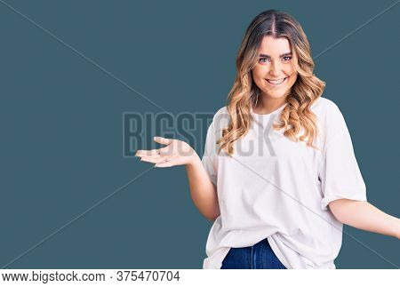 Young caucasian woman wearing casual clothes smiling showing both hands open palms, presenting and advertising comparison and balance 