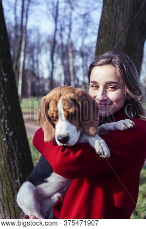 Pretty Young Girl In Redd Coat Playing With Dog Outside In Green Park, Lifestyle People Concept