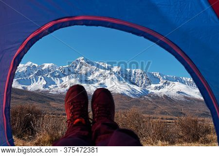 Tent Lookout On A Camp In The Mountains. Feet Hiker Relaxing Enjoying View From Tent Camping Entranc