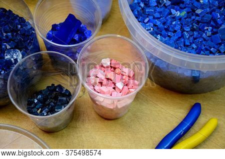 Smalt Of Different Colors In Plastic Containers On The Table. Selective Focus.