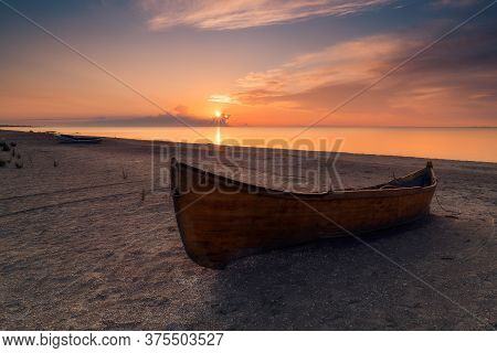 Wooden Fishing Boat Resting On The Beach At Sunrise Shot In Romania On The Black Sea Coast In Corbu,