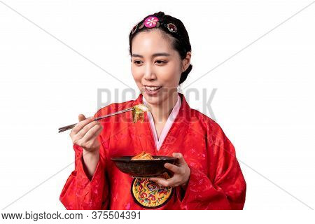 Pretty Asian Woman Wearing A Traditional Red Hanbok, Eating Kimchi Which Made From The Permentation 