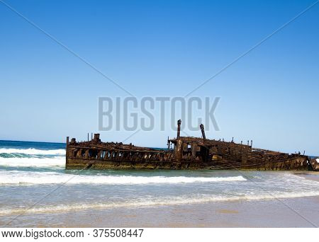 Photograph Of The Shipwreck Of The Ss Maheno On Fraser Island With A Cloudless Sky In The Background