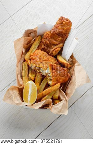 Fish And Chips With Lemon In Greaseproof Paper