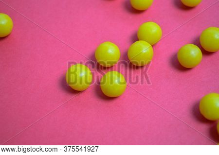 Bright Yellow Vitamins Of Round Volumetric Form On A Pink Background. Pills To Strengthen Human Immu