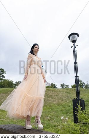 Young Girl In A Long Evening Dress On An Impromptu Catwalk