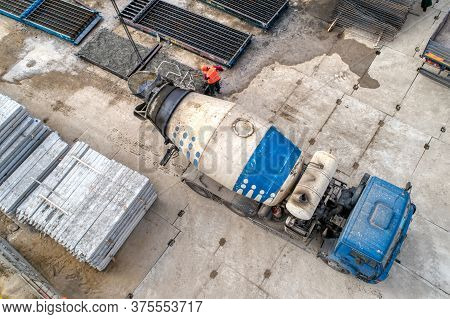 A Concrete Mixer Truck Transports Concrete Through A Construction Site. Transposing Liquid Concrete 