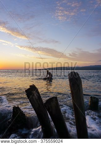 Banyuwangi, Indonesia - July 04, 2020 : A Woman Playing With The Dogs At Watudodol Beach Banyuwangi 