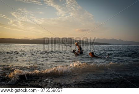 Banyuwangi, Indonesia - July 04, 2020 : A Woman Playing With The Dogs At Watudodol Beach Banyuwangi 