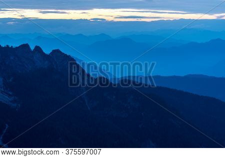 Spectacular View Of Blue Mountain Ranges Silhouettes And Fog In Valleys. Julian Alps, Triglav Nation