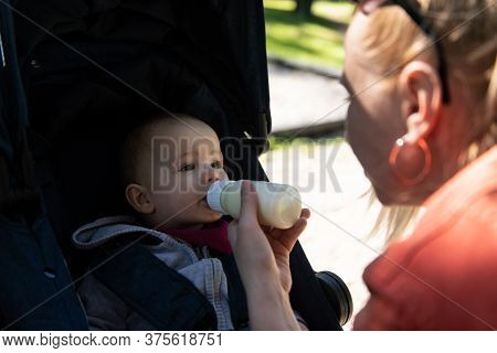 Om Feeding Infant Boy With Drink