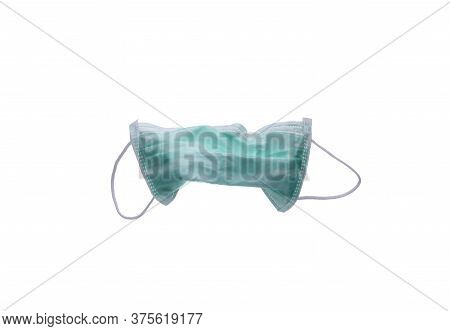 Used Green Surgical Face Mask Isolated On White Background With Copy Space. Medical Waste. Infectiou