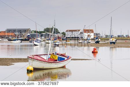 Safety Boat Lies In Shallow Water In Front Of The Tide Mill At Woodbridge On The Deben Estuary In Su