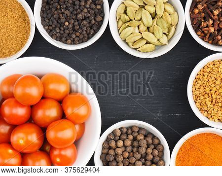 Red Small Cherry Tomato In White Bowl, Spice Cloves, Red Chili Pepper, Black Pepper, Masala Powder, 