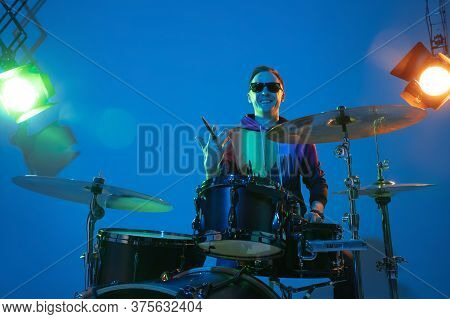 Rythmic. Young Inspired And Expressive Musician, Drummer Performing On Gradient Colored Background I