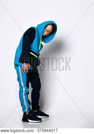 Cute Smiling Boy In A Modern Cotton Tracksuit With A Cute Haircut, Putting A Hood On His Head Foolin