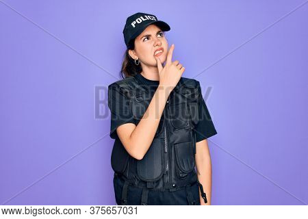 Young police woman wearing security bulletproof vest uniform over purple background Thinking worried about a question, concerned and nervous with hand on chin