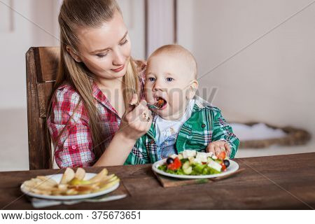 Mother Feeding Child. First Solid Food For Young Kid.