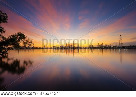 Oil Refinery Plant Chemical Factory And Power Plant With Many Storage Tanks And Pipelines At Sunrise