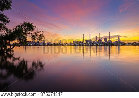 Oil Refinery Plant Chemical Factory And Power Plant With Many Storage Tanks And Pipelines At Sunrise
