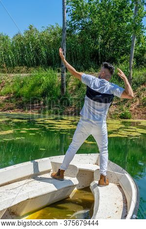 Young Man In White Pants And Modern Styling Posing In The Freshwater Pond Of Clot De La Mare De Deu 
