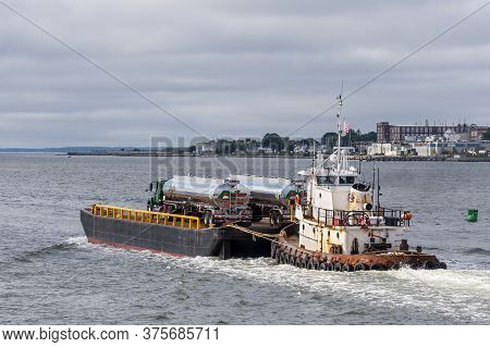 New Bedford, Massachusetts, Usa - July 7, 2020: Tug Sirius Pushing Barge Carrying Fuel Trucks Out Of