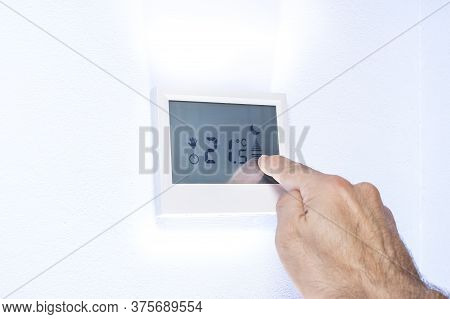 Hand Pressing On A Touch Screen Of A Thermostat Adjusting The Temperature
