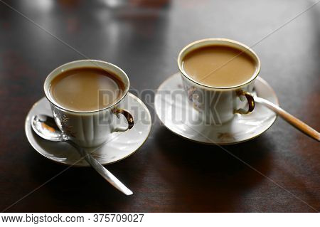 Two Tiny Coffee Cup With Hot Milk Coffee And Teaspoons