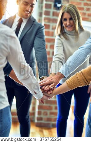 Group of business workers standing with hands together at the office