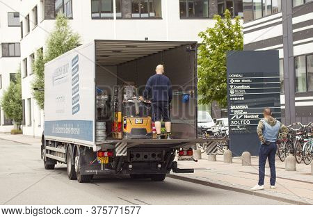 Delivery Man Unloaded Truck With A Forklift On A Tailgate Loader Of A Delivery Truck In Front Of An 