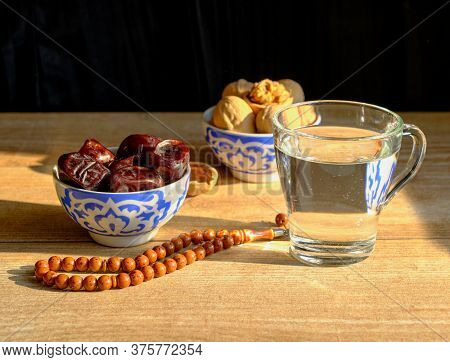 Cups With A Traditional Oriental Pattern With Dates And Walnuts, A Glass Of Clear Water, Stone Rosar