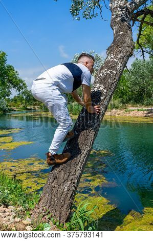 Young Man In White Pants And Modern Styling Posing In The Freshwater Pond Of Clot De La Mare De Deu 