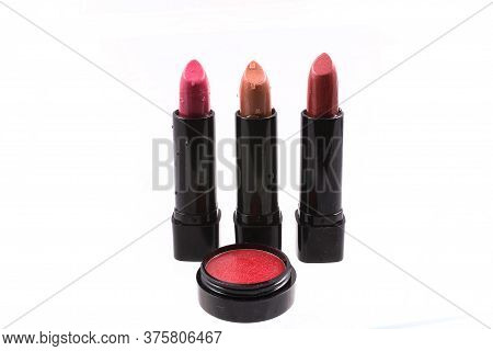 Three Red Lipsticks And Lip Gloss On White Background