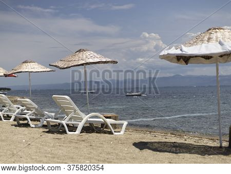 Sun Beds And Umbrellas By The Sea.