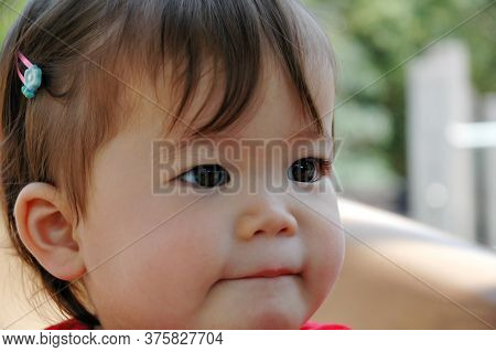 Close-up Of Beautiful Baby Asian Girl Sucking Her Bottom Lip.