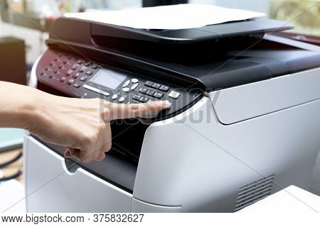 Woman Hands Putting A Sheet Of Paper Into A Copying Device Or Printer In The Office