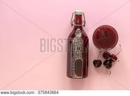 Cold Cherry Juice In A Glass Bottle With Ripe Berries. Top View, Copy Space For Text. The Concept Of