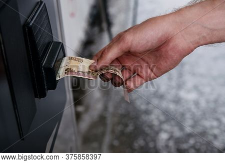 The Man’s Hand Pays 100 Rubles In A Machine With A Paper Russian Bill